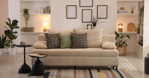 Photo of Comfortable sofa with cushions in room. Interior design
