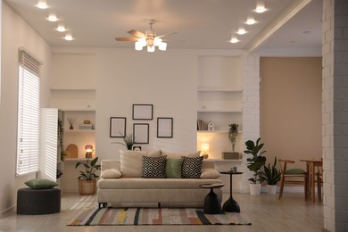 Photo of Comfortable sofa with cushions in room. Interior design