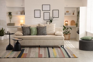 Photo of Comfortable sofa with cushions in room. Interior design