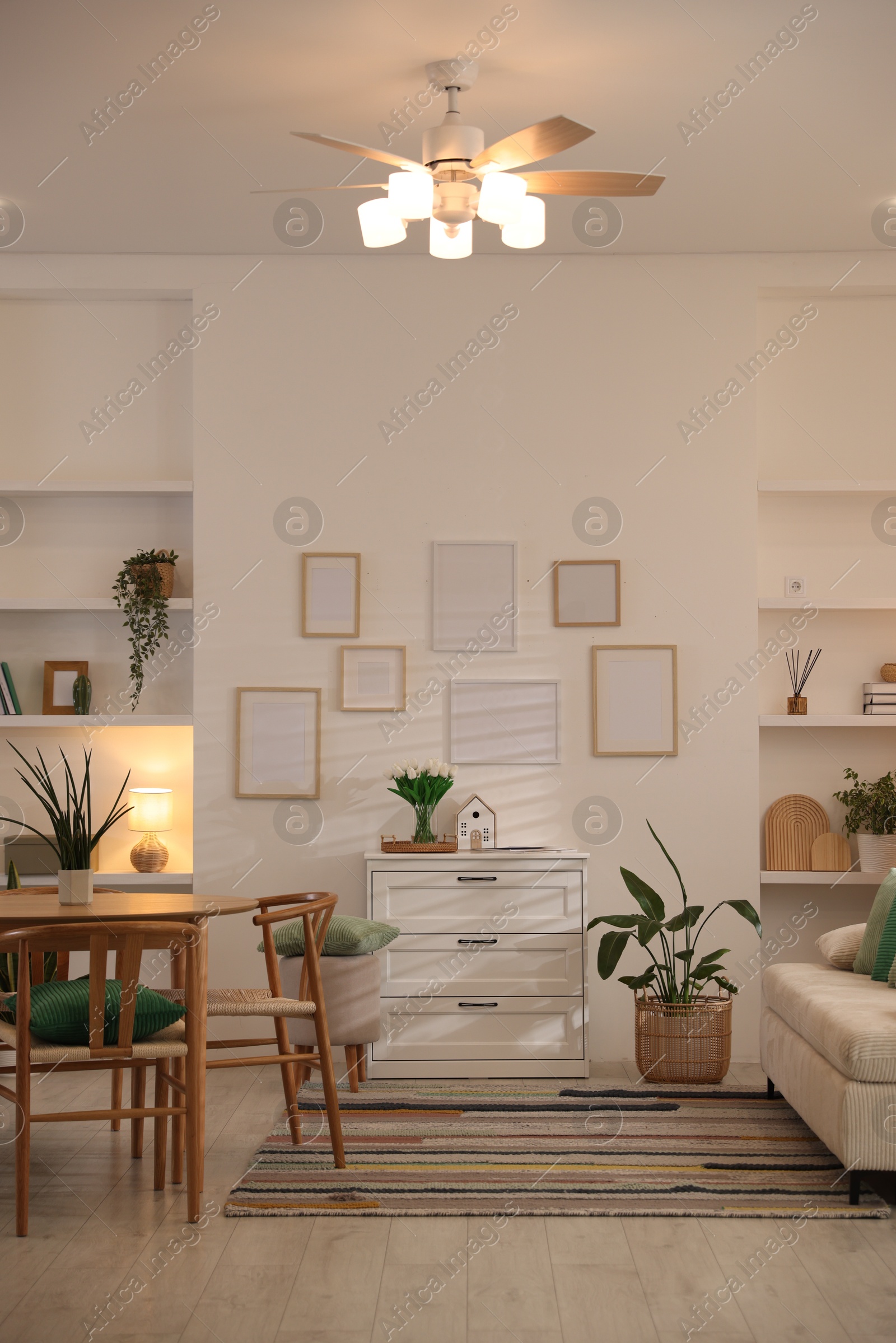 Stylish dining table with chairs and comfortable sofa in room. Interior design Photo of Stylish dining table with chairs and comfortable sofa in room. Interior design