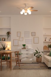 Photo of Stylish dining table with chairs and comfortable sofa in room. Interior design