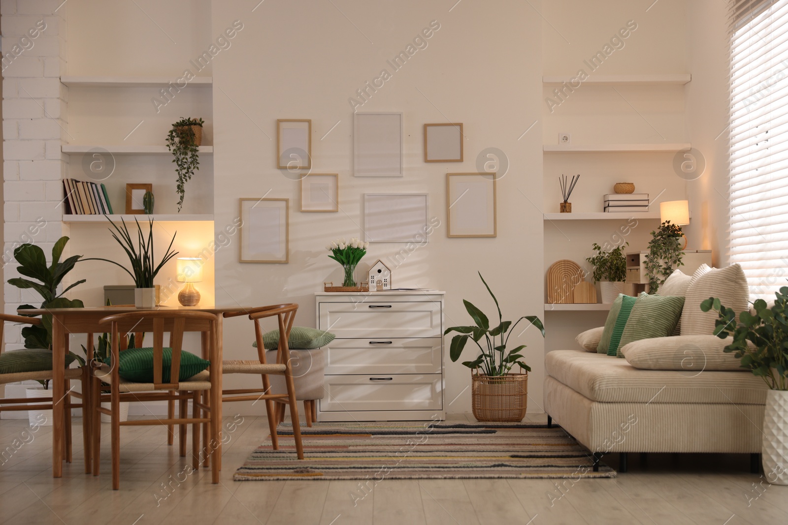 Stylish dining table with chairs and comfortable sofa in room. Interior design Photo of Stylish dining table with chairs and comfortable sofa in room. Interior design