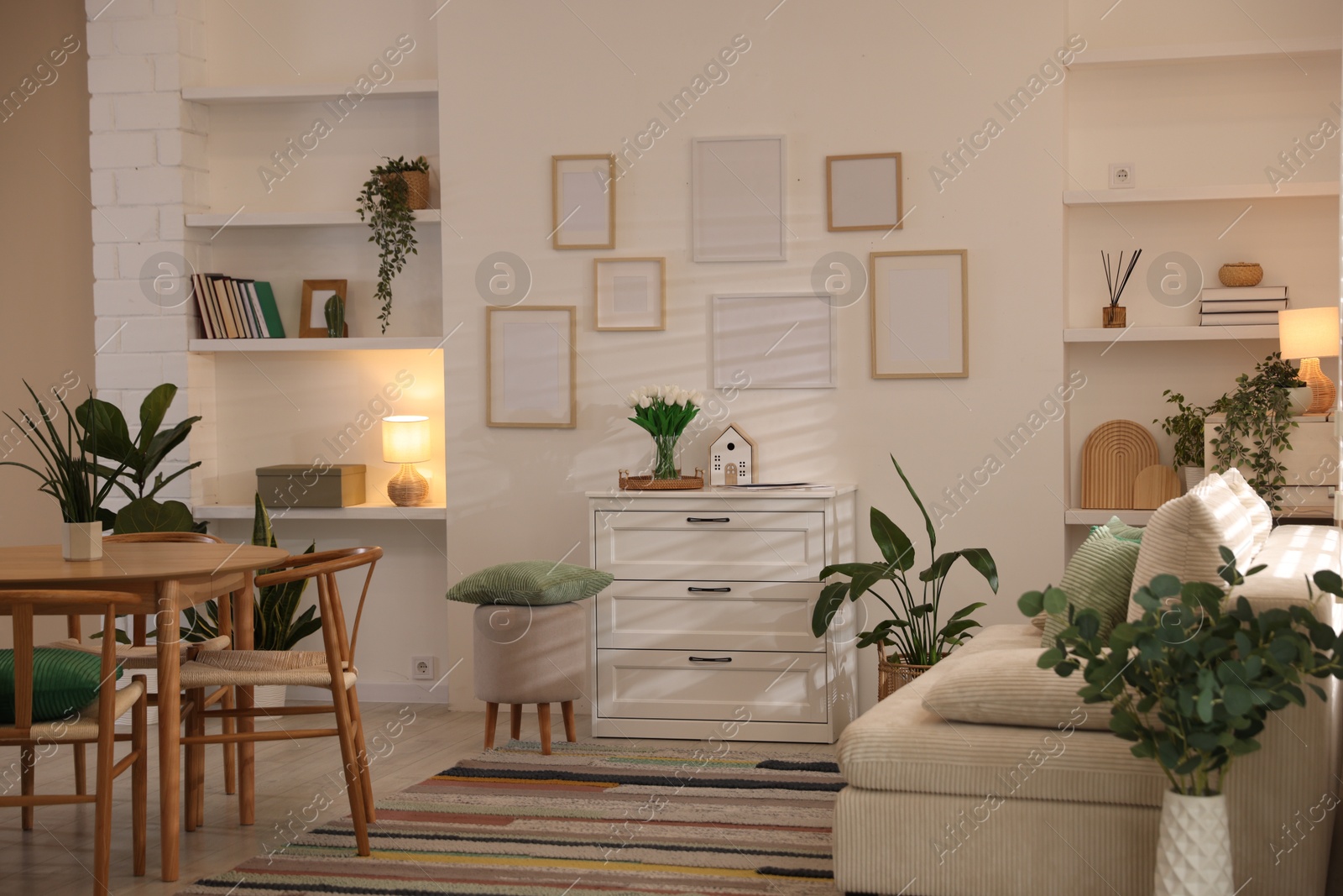 Stylish dining table with chairs and comfortable sofa in room. Interior design Photo of Stylish dining table with chairs and comfortable sofa in room. Interior design