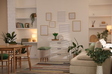 Photo of Stylish dining table with chairs and comfortable sofa in room. Interior design