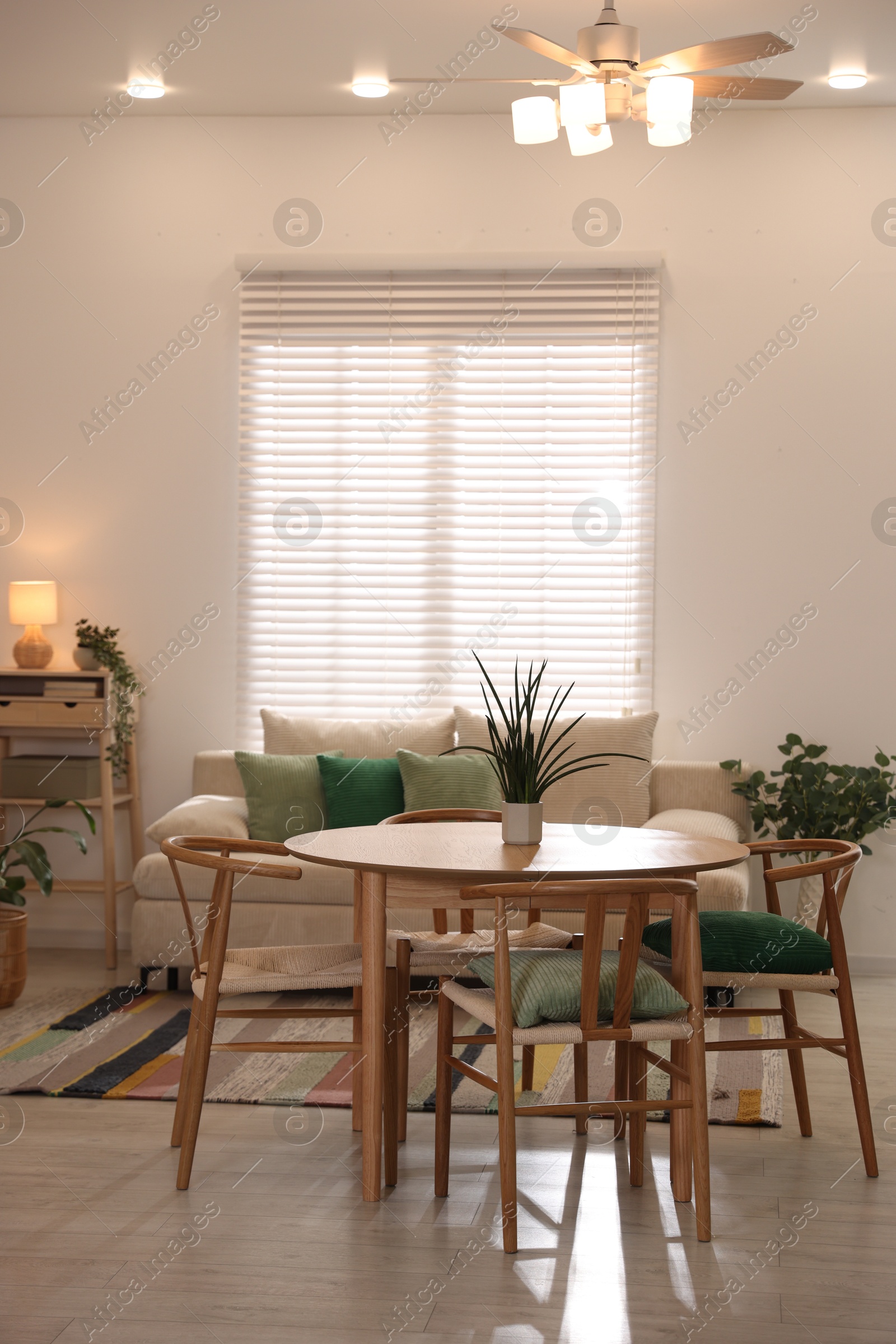 Stylish dining table with chairs and comfortable sofa in room. Interior design Photo of Stylish dining table with chairs and comfortable sofa in room. Interior design