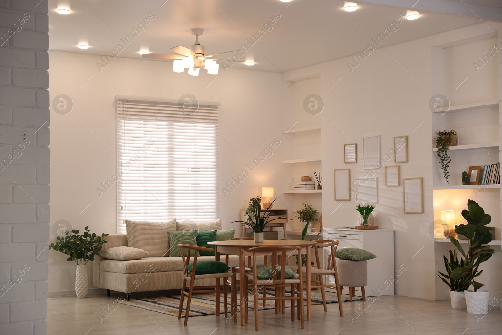 Stylish dining table with chairs and comfortable sofa in room. Interior design Photo of Stylish dining table with chairs and comfortable sofa in room. Interior design