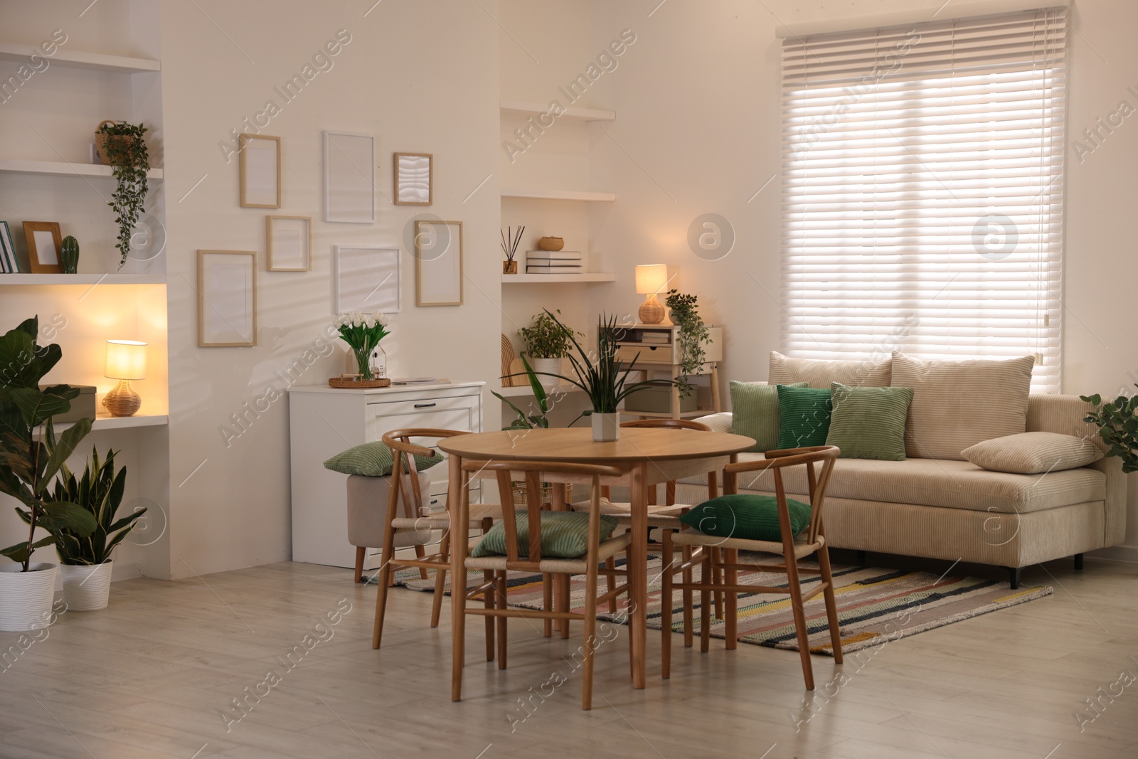 Stylish dining table with chairs and comfortable sofa in room. Interior design Photo of Stylish dining table with chairs and comfortable sofa in room. Interior design
