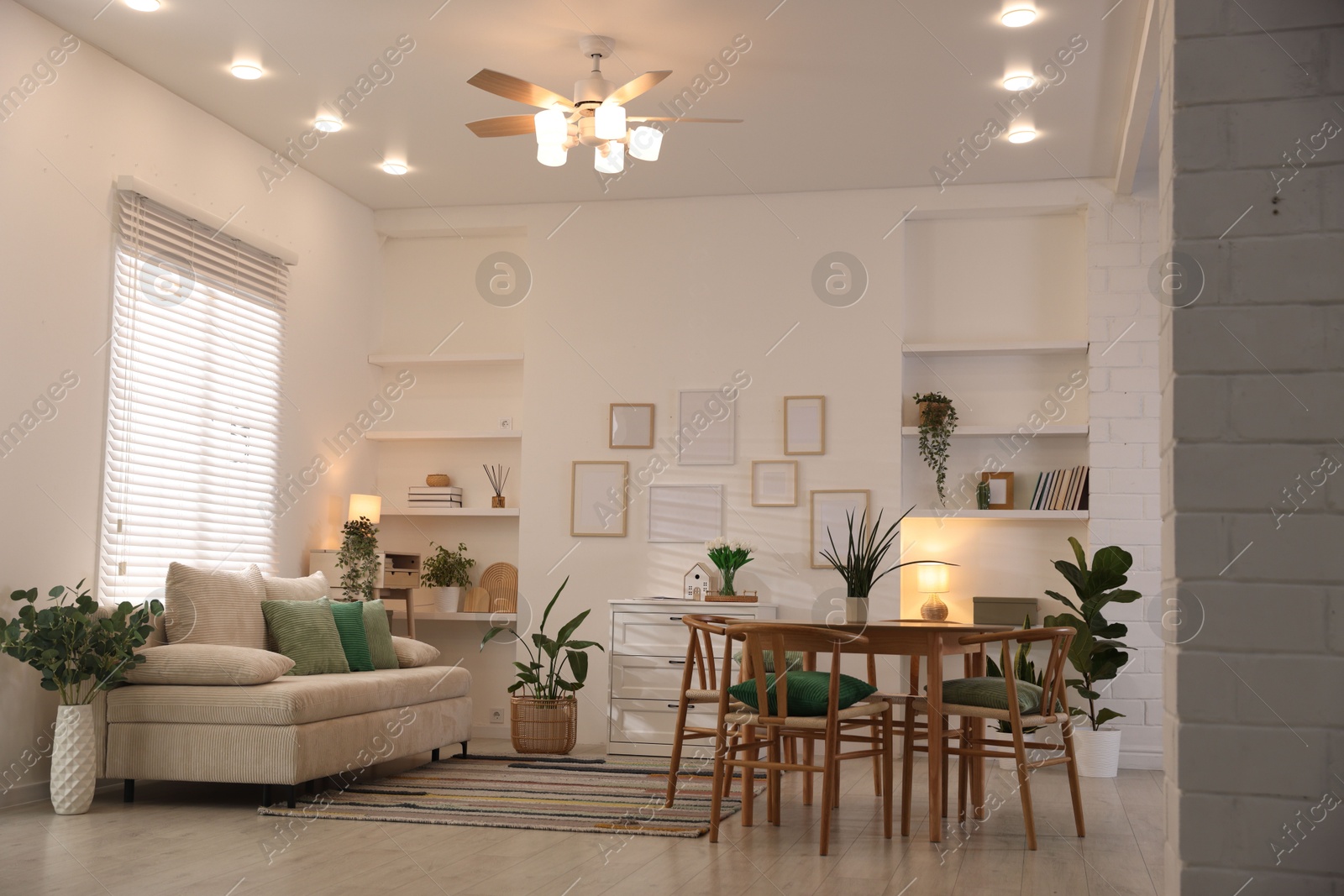 Stylish dining table with chairs and comfortable sofa in room. Interior design Photo of Stylish dining table with chairs and comfortable sofa in room. Interior design