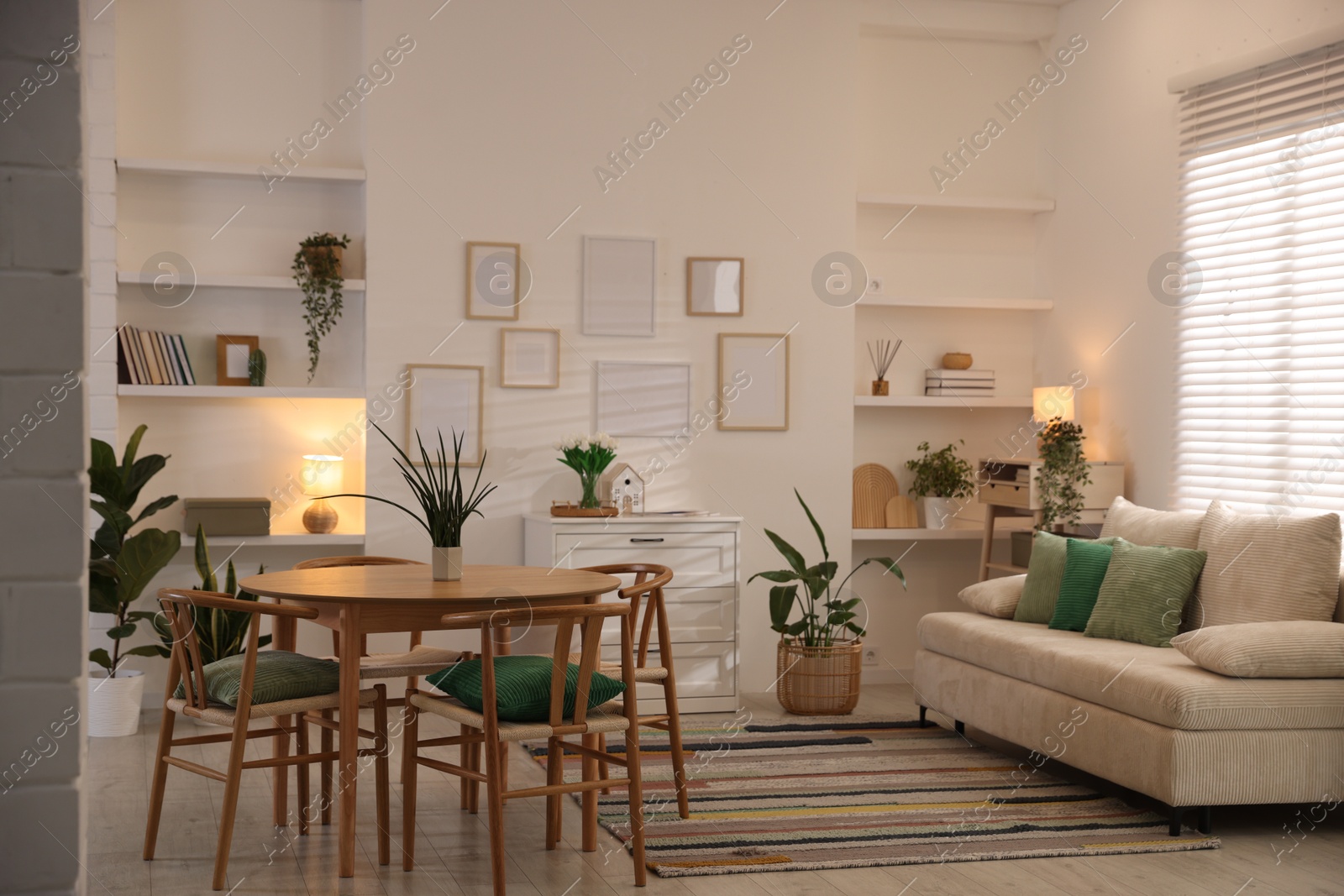 Stylish dining table with chairs and comfortable sofa in room. Interior design Photo of Stylish dining table with chairs and comfortable sofa in room. Interior design