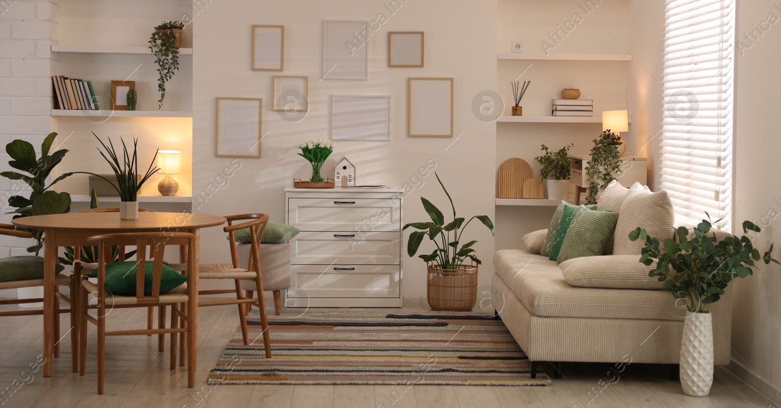 Stylish dining table with chairs and comfortable sofa in room. Interior design Photo of Stylish dining table with chairs and comfortable sofa in room. Interior design