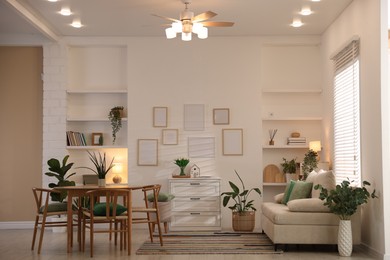 Photo of Stylish dining table with chairs and comfortable sofa in room. Interior design