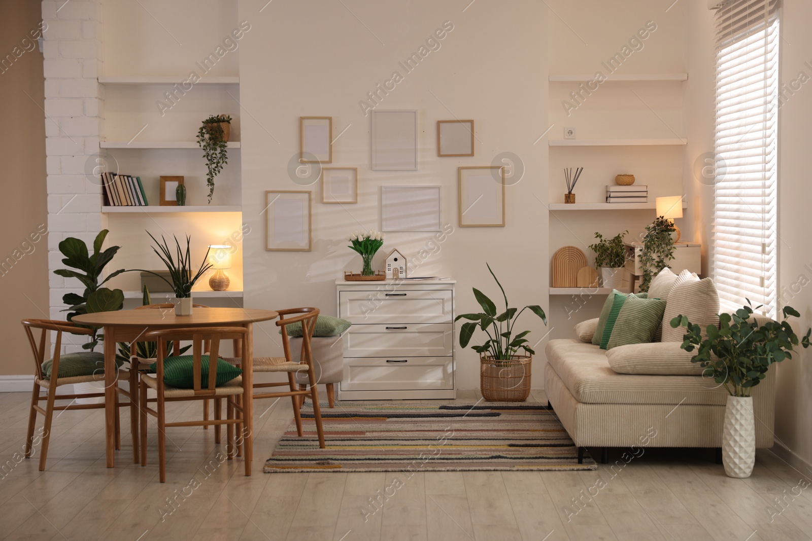 Stylish dining table with chairs and comfortable sofa in room. Interior design Photo of Stylish dining table with chairs and comfortable sofa in room. Interior design