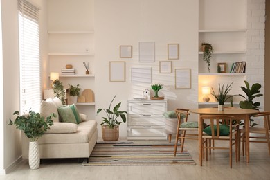 Photo of Stylish dining table with chairs and comfortable sofa in room. Interior design