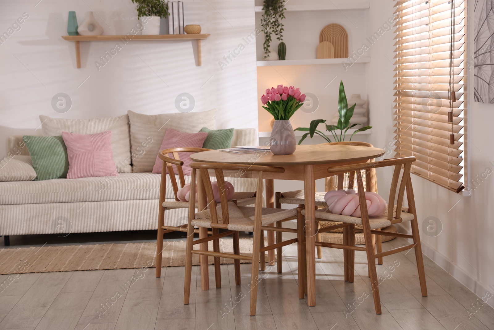 Stylish dining table with chairs and comfortable sofa in room. Interior design Photo of Stylish dining table with chairs and comfortable sofa in room. Interior design