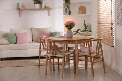 Photo of Stylish dining table with chairs and comfortable sofa in room. Interior design