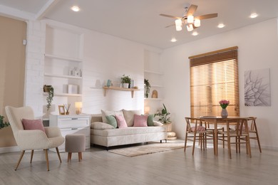 Photo of Stylish dining table with chairs and comfortable sofa in room. Interior design
