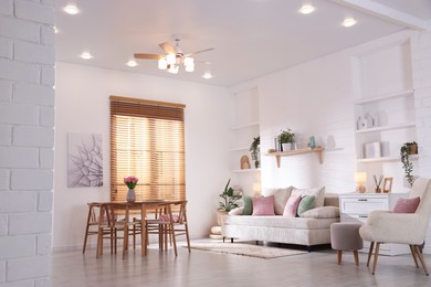 Photo of Stylish dining table with chairs and comfortable sofa in room. Interior design