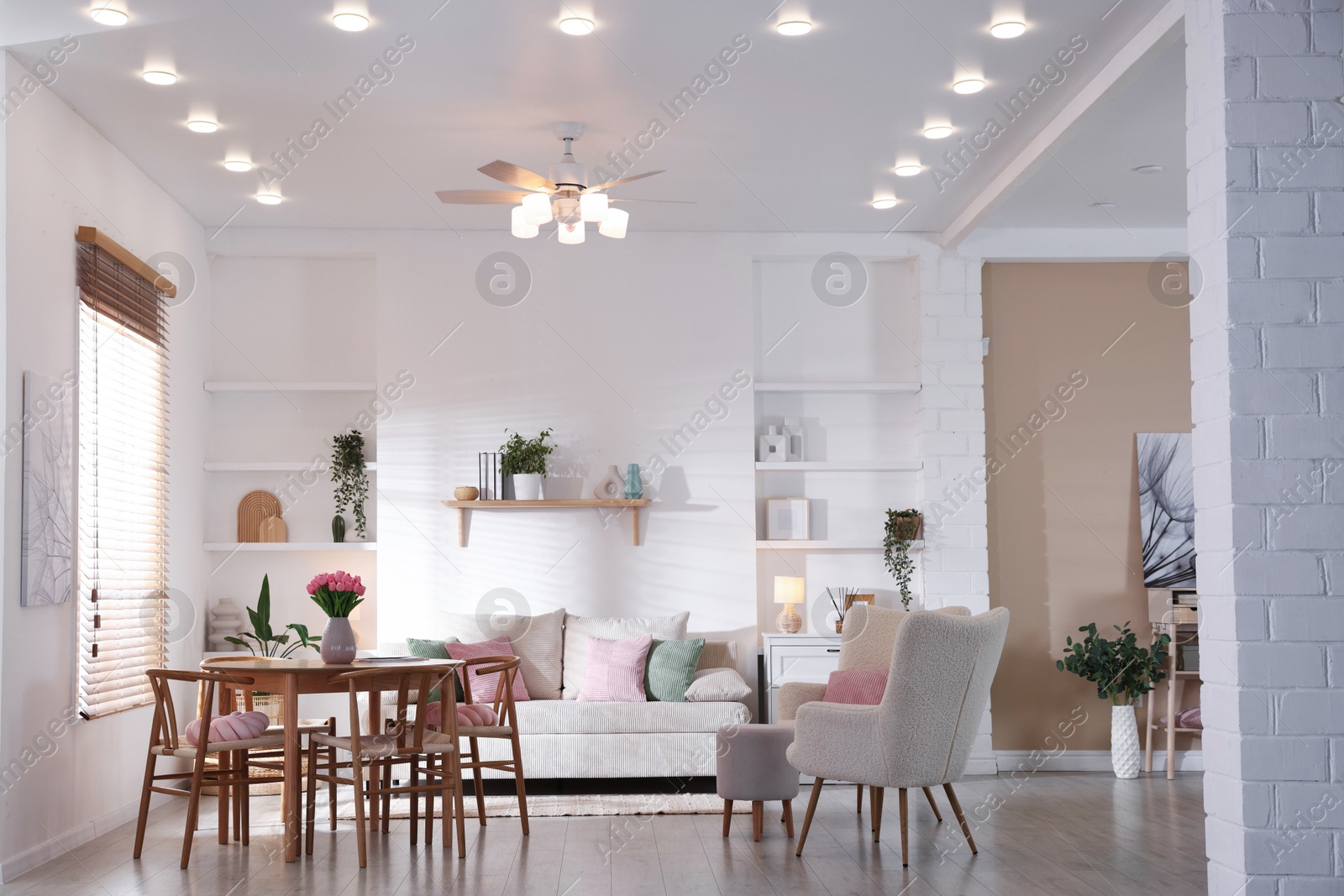 Stylish dining table with chairs and comfortable sofa in room. Interior design Photo of Stylish dining table with chairs and comfortable sofa in room. Interior design