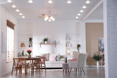 Photo of Stylish dining table with chairs and comfortable sofa in room. Interior design