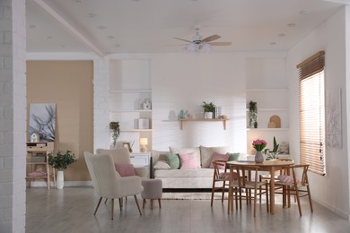 Photo of Stylish dining table with chairs and comfortable sofa in room. Interior design