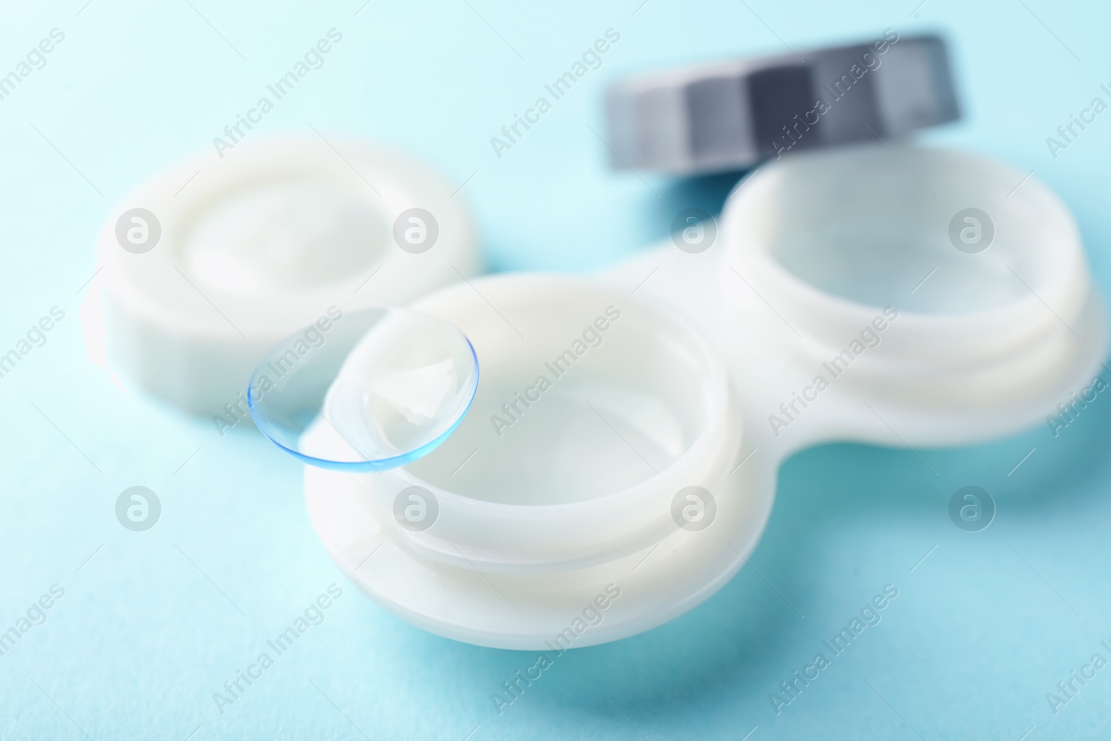 Contact lenses and case on light blue background, closeup Photo of Contact lenses and case on light blue background, closeup