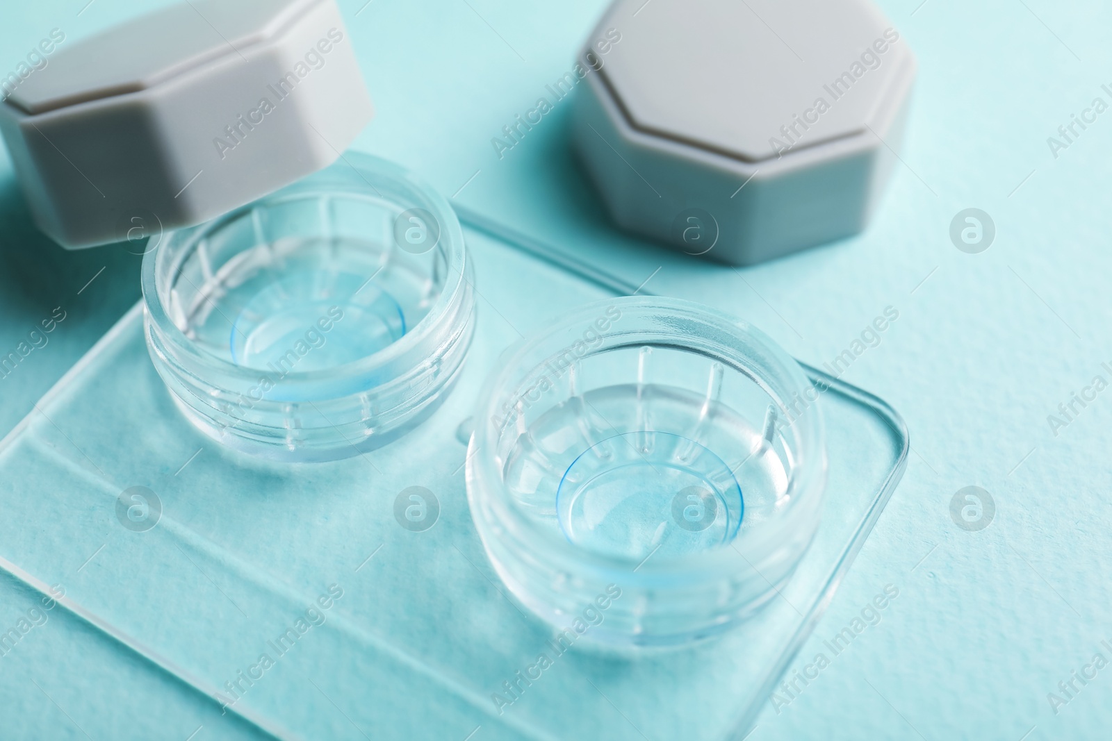 Contact lenses in case on light turquoise background, closeup Photo of Contact lenses in case on light turquoise background, closeup