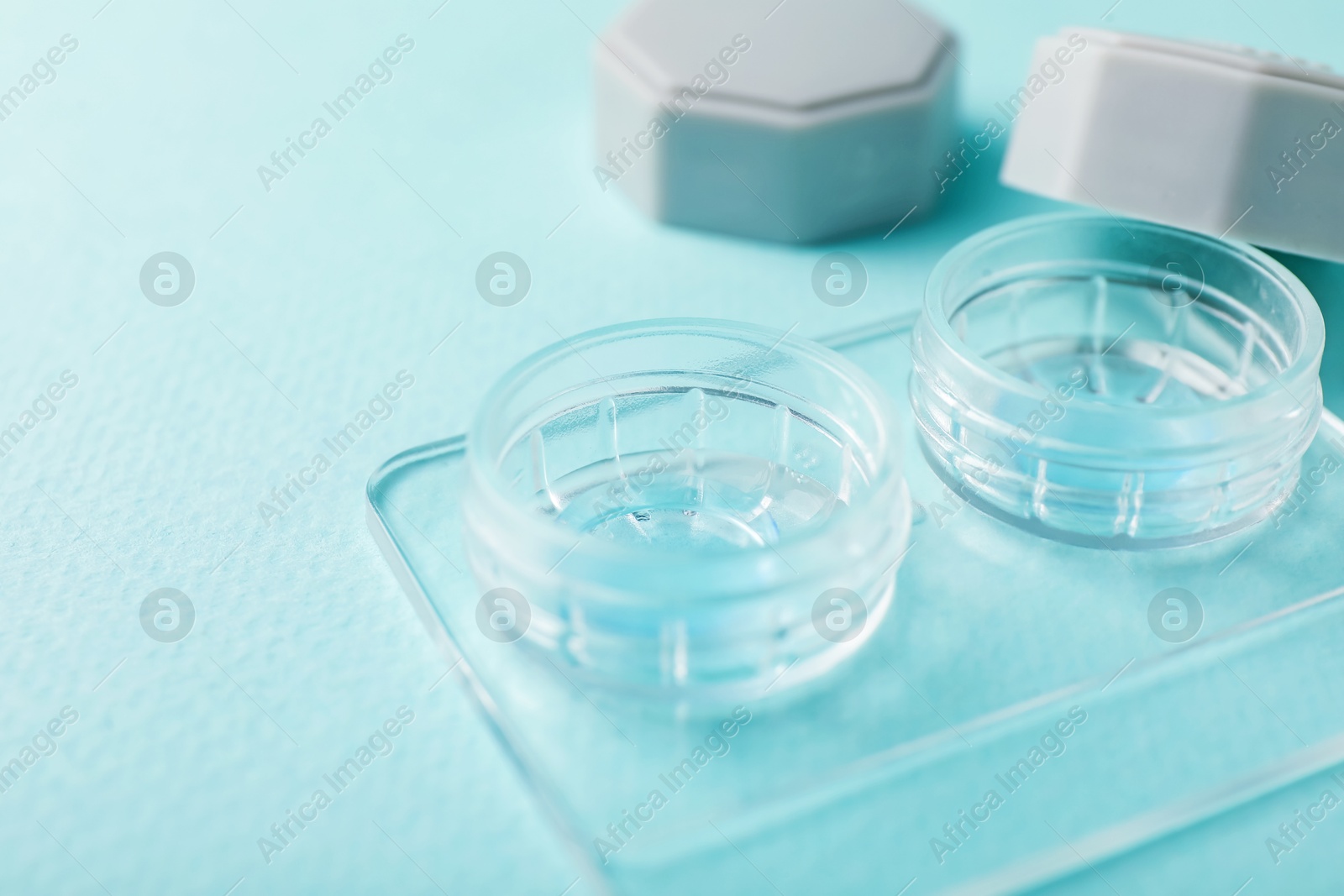 Contact lenses in case on light turquoise background, closeup Photo of Contact lenses in case on light turquoise background, closeup