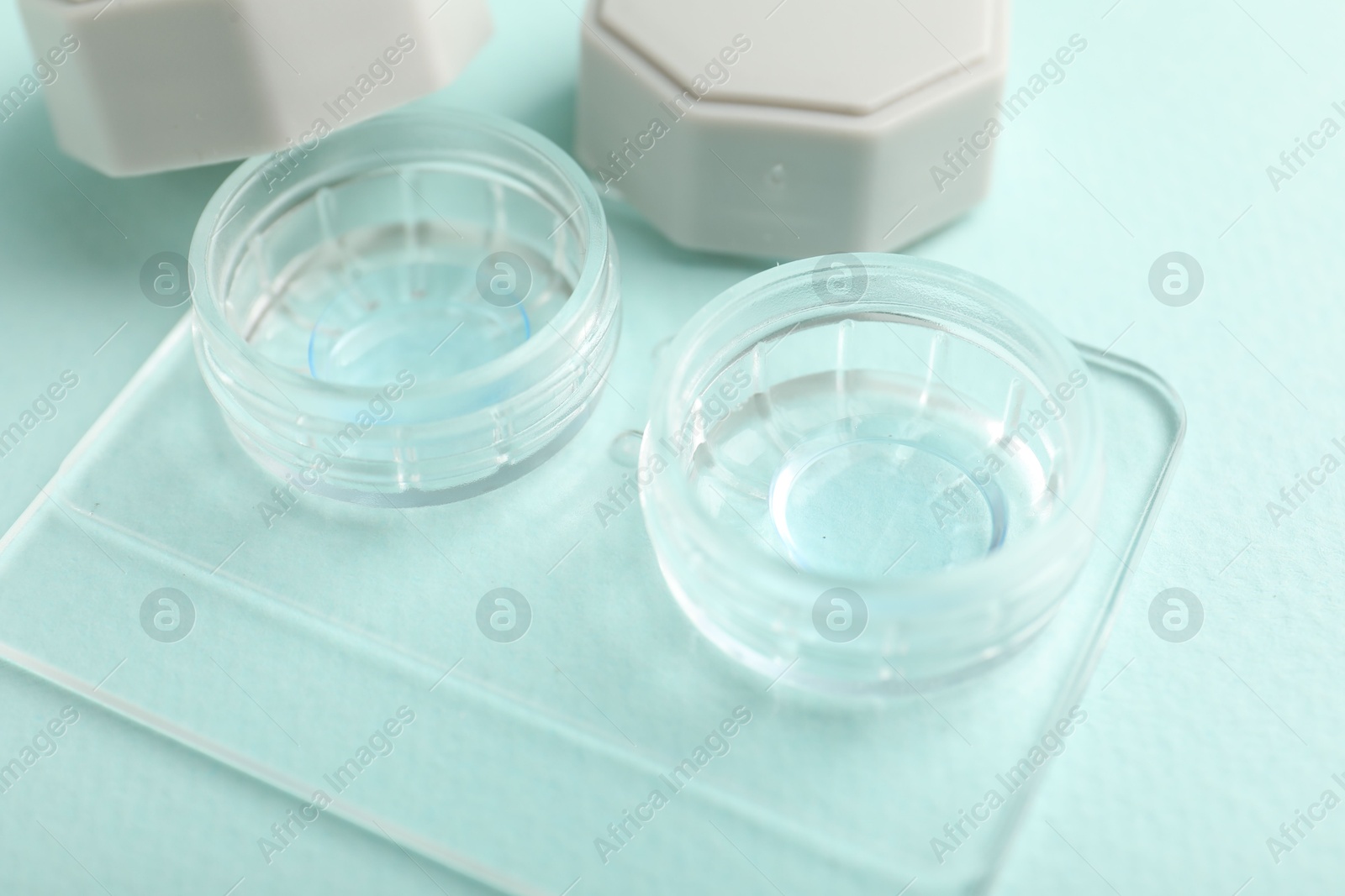 Contact lenses in case on light turquoise background, closeup Photo of Contact lenses in case on light turquoise background, closeup