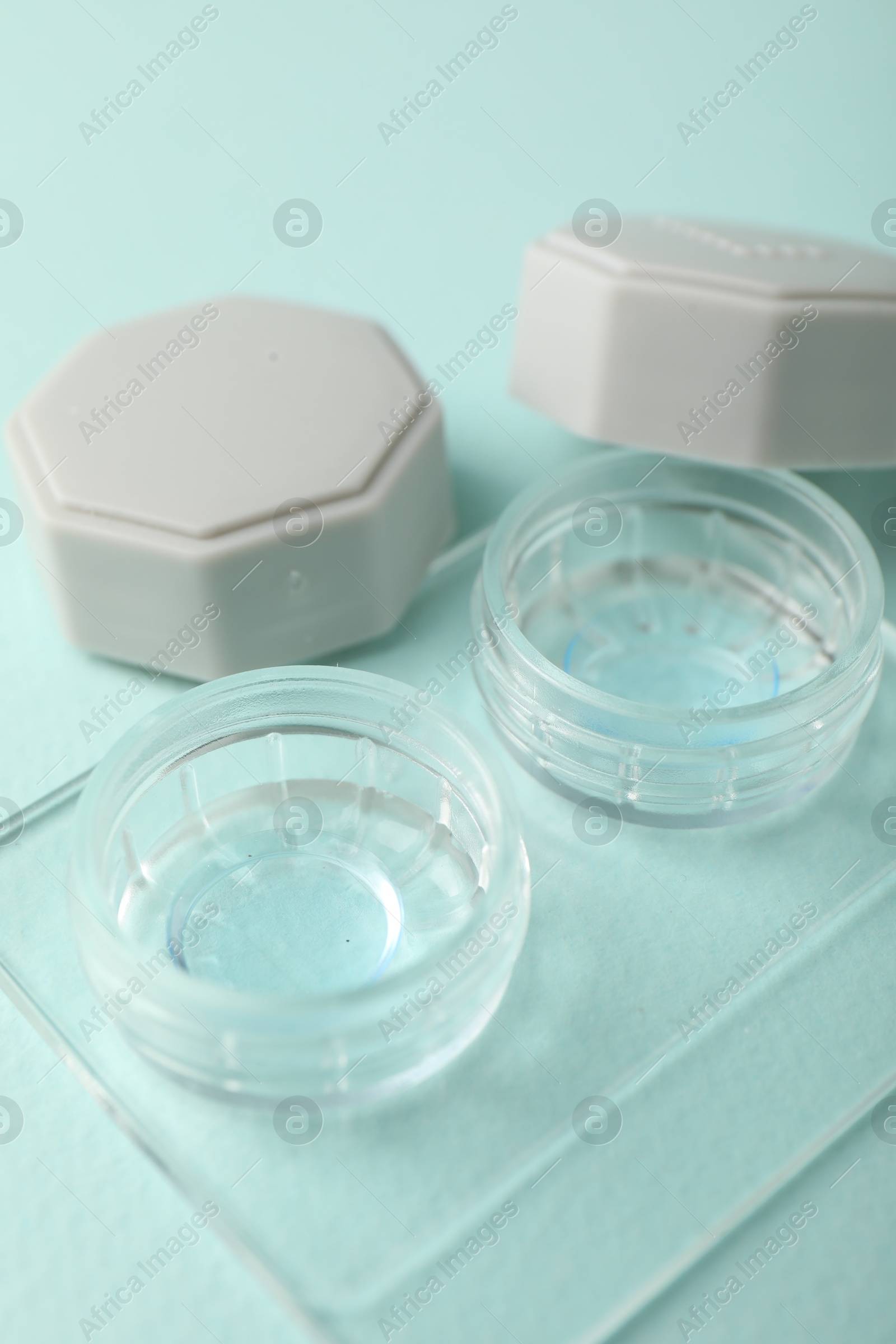 Contact lenses in case on light turquoise background, closeup Photo of Contact lenses in case on light turquoise background, closeup