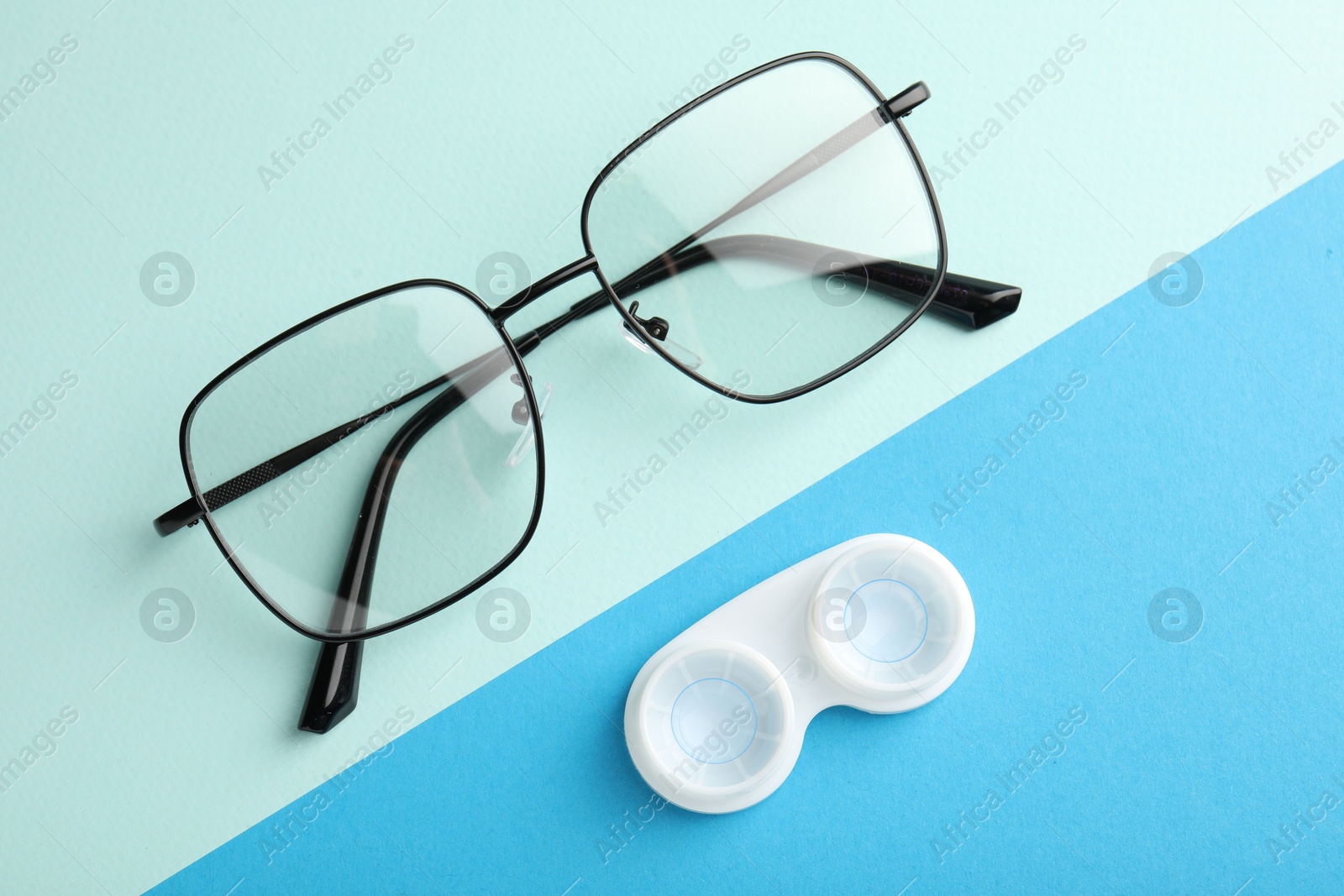 Contact lenses in case and glasses on color background, flat lay Photo of Contact lenses in case and glasses on color background, flat lay