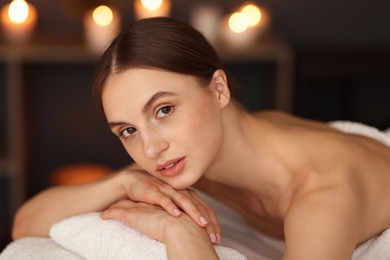 Photo of Beautiful woman relaxing in spa salon, closeup