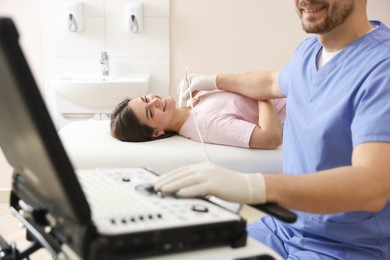 Photo of Sonographer conducting ultrasound examination of woman's thyroid gland in clinic, closeup