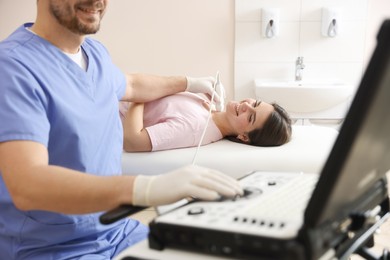 Photo of Sonographer conducting ultrasound examination of woman's thyroid gland in clinic, closeup