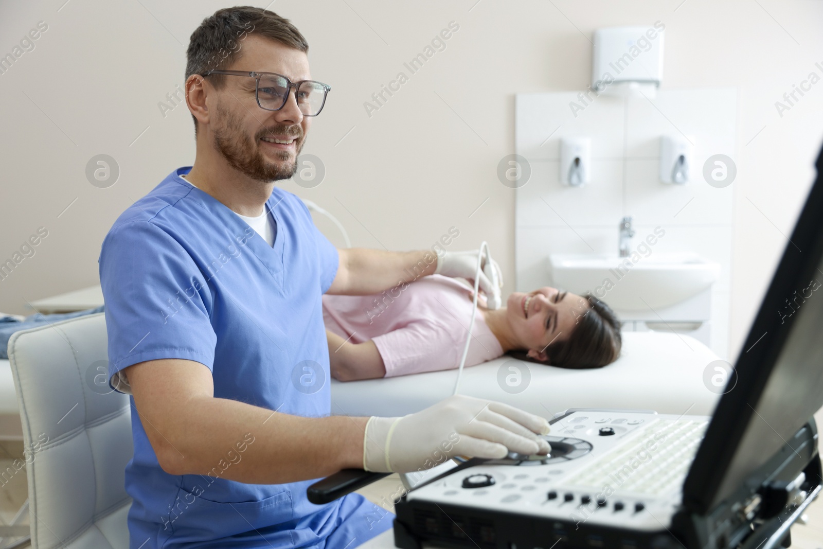 Sonographer conducting ultrasound examination of woman's thyroid gland in clinic Photo of Sonographer conducting ultrasound examination of woman's thyroid gland in clinic