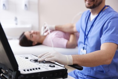 Photo of Sonographer conducting ultrasound examination of woman's thyroid gland in clinic, closeup