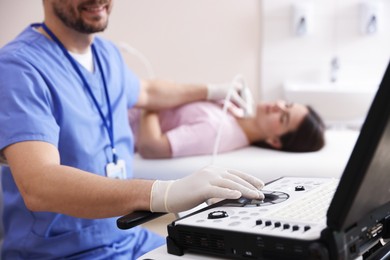 Photo of Sonographer conducting ultrasound examination of woman's thyroid gland in clinic, closeup