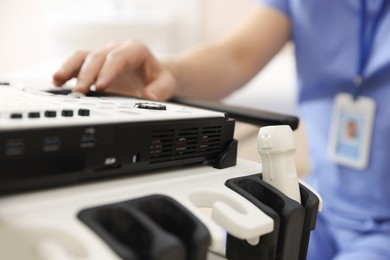 Photo of Professional sonographer with ultrasound machine in clinic, closeup