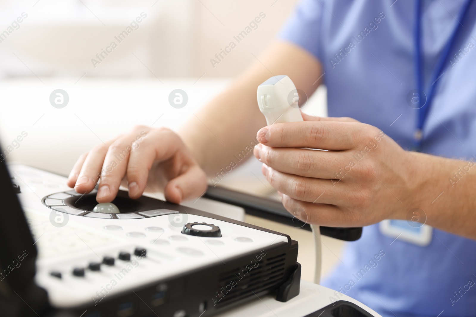 Sonographer with transducer and ultrasound machine in clinic, closeup Photo of Sonographer with transducer and ultrasound machine in clinic, closeup