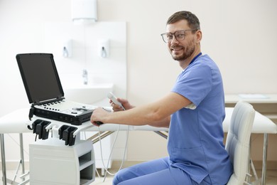 Photo of Professional sonographer with ultrasound machine in clinic