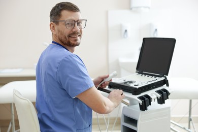 Photo of Professional sonographer with ultrasound machine in clinic