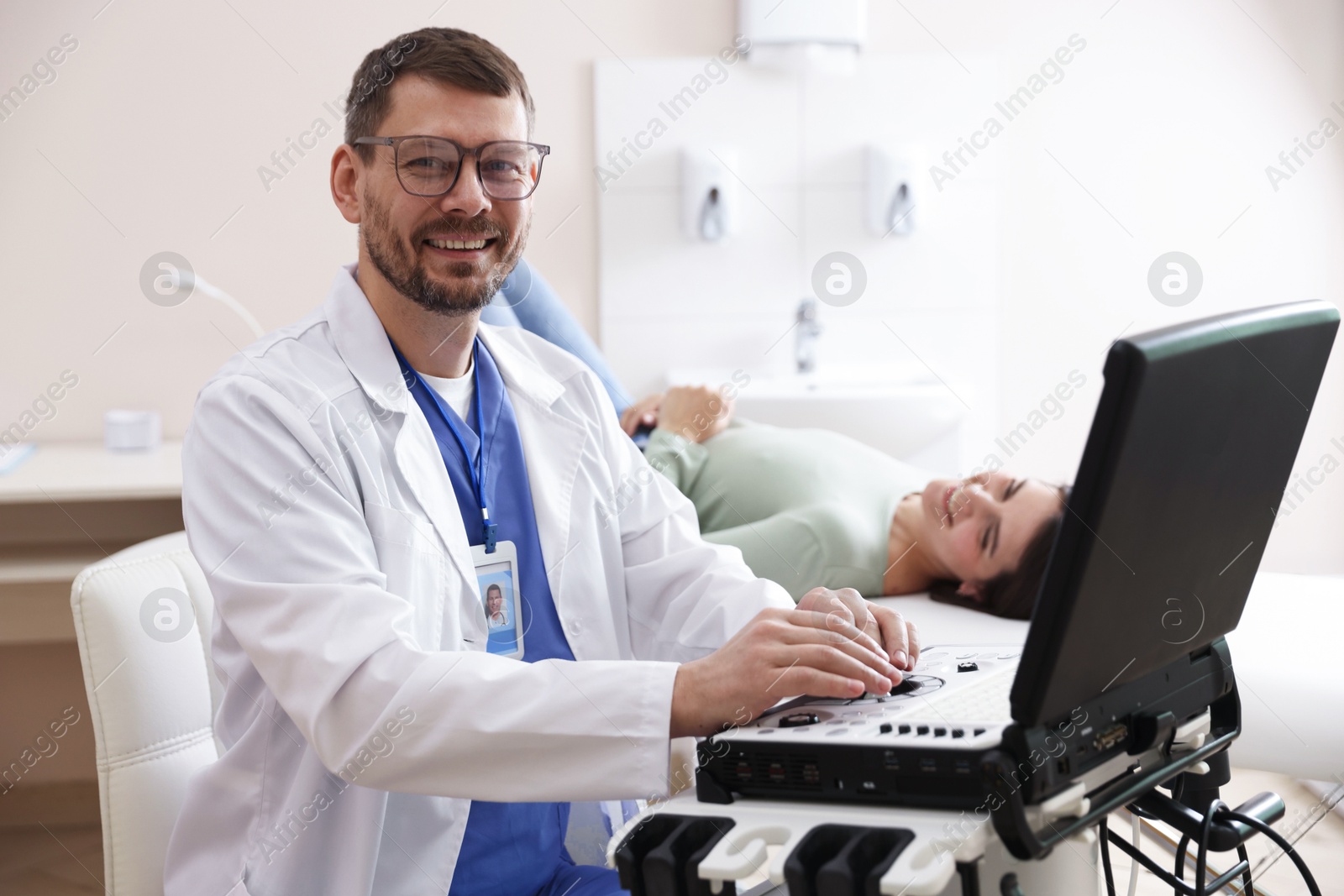 Sonographer with ultrasound machine and woman waiting for examination in clinic, selective focus Photo of Sonographer with ultrasound machine and woman waiting for examination in clinic, selective focus