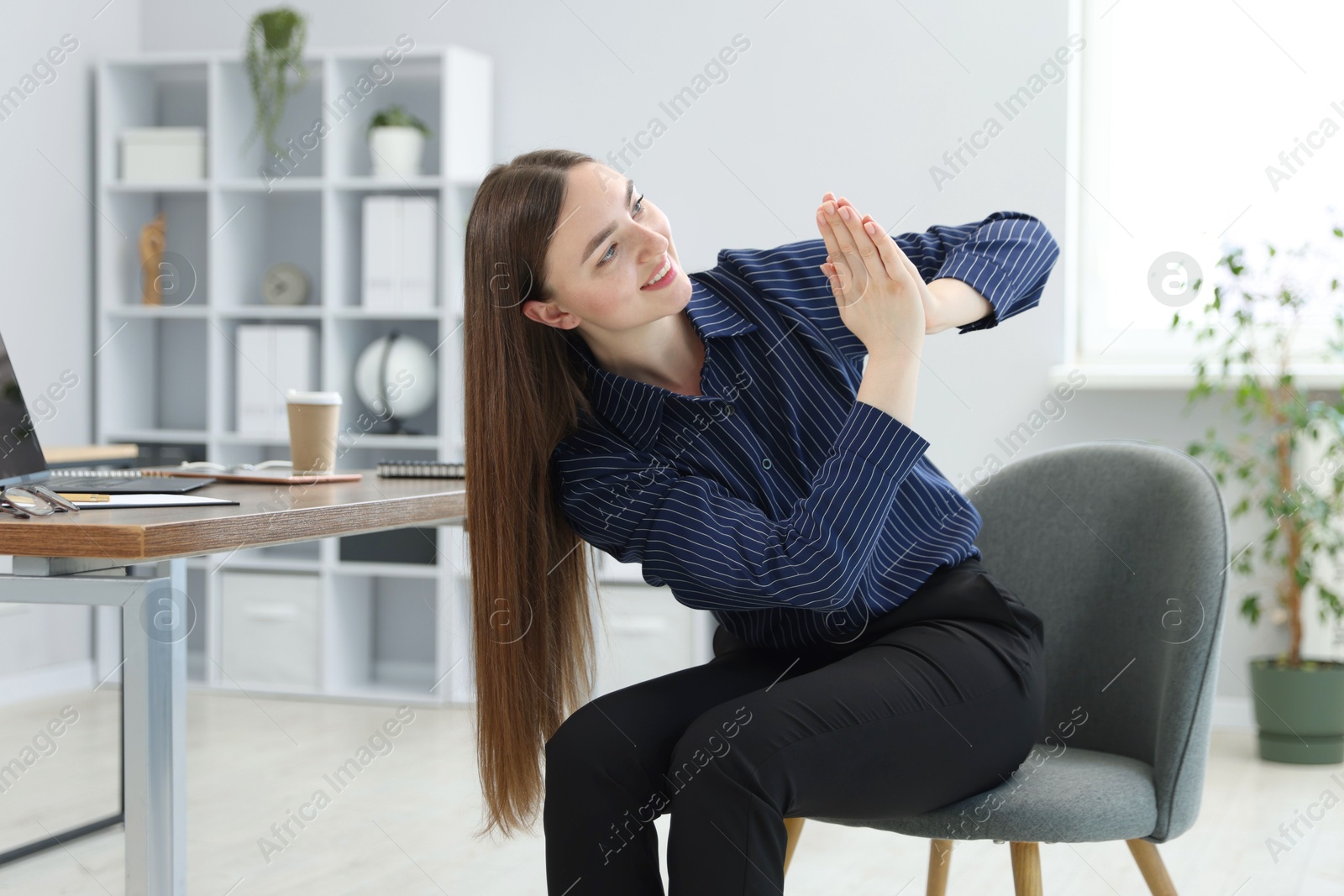 Beautiful woman stretching on chair in office Photo of Beautiful woman stretching on chair in office
