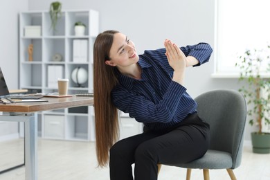 Photo of Beautiful woman stretching on chair in office