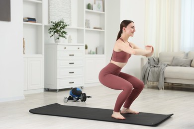 Photo of Beautiful woman exercising on fitness mat at home