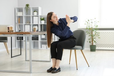Photo of Beautiful woman stretching on chair in office