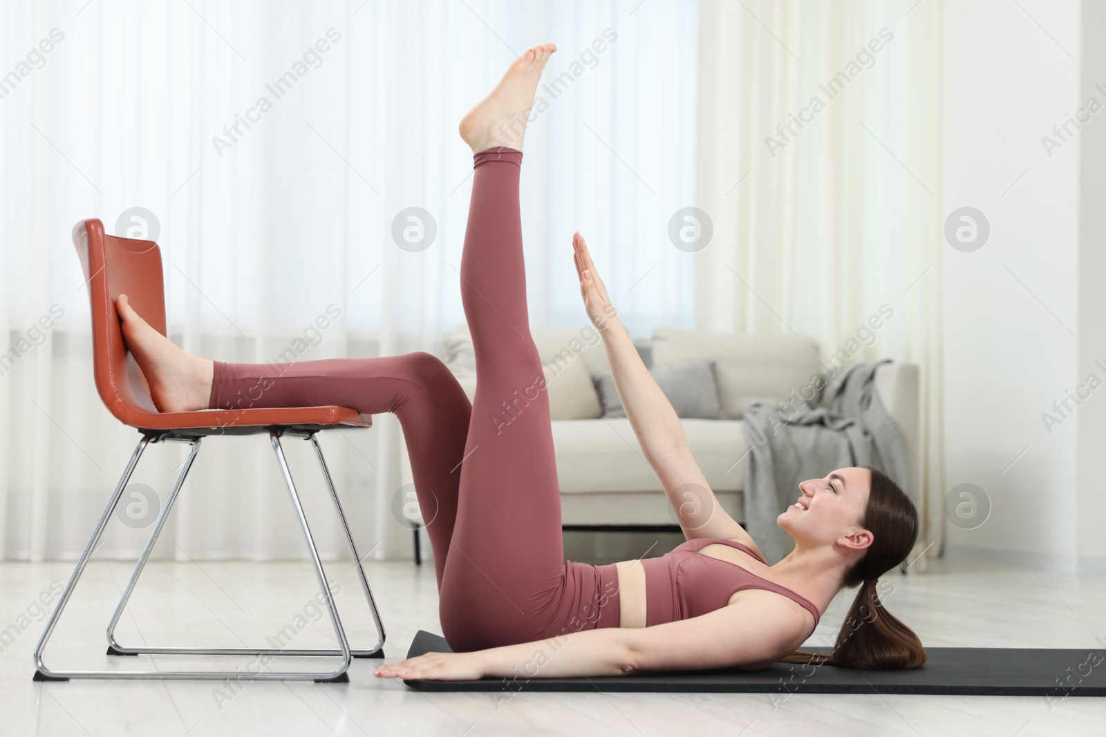 Beautiful woman exercising with chair at home Photo of Beautiful woman exercising with chair at home