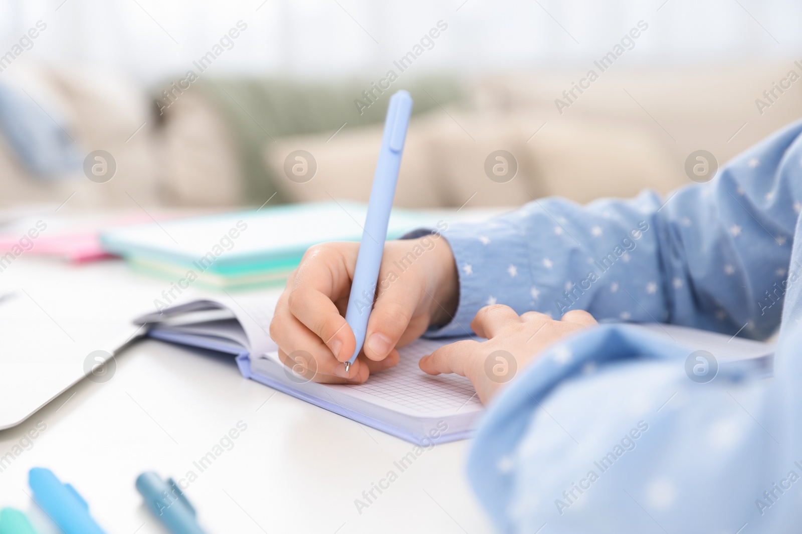 Little girl doing homework at table indoors, closeup Photo of Little girl doing homework at table indoors, closeup
