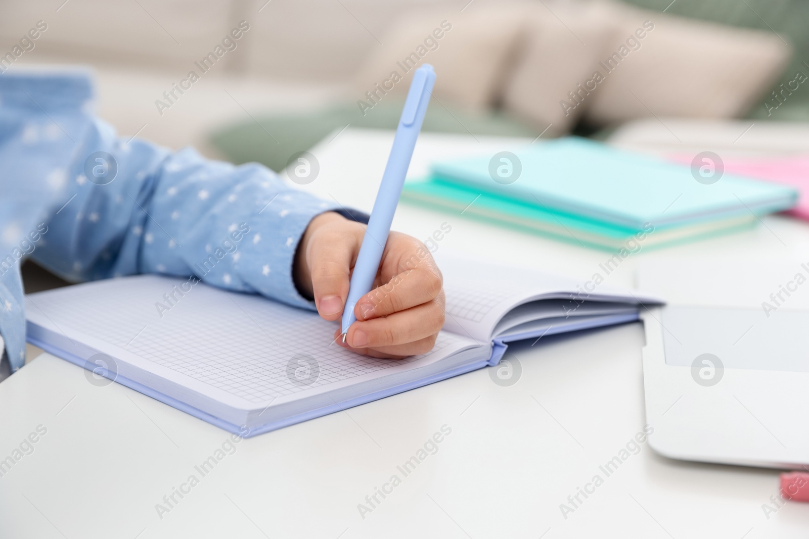 Little girl doing homework at table indoors, closeup Photo of Little girl doing homework at table indoors, closeup