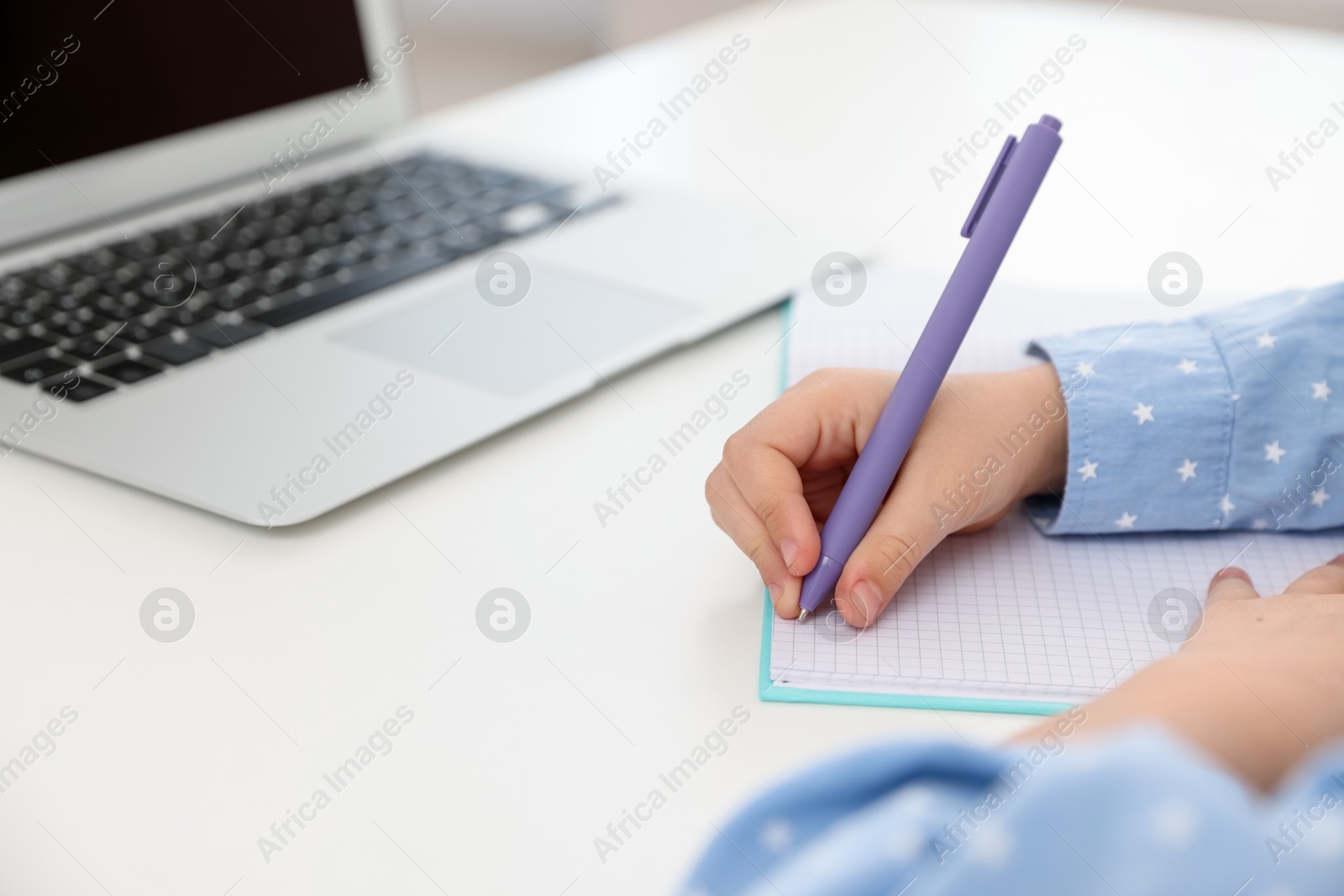 Little girl doing homework at table indoors, closeup Photo of Little girl doing homework at table indoors, closeup