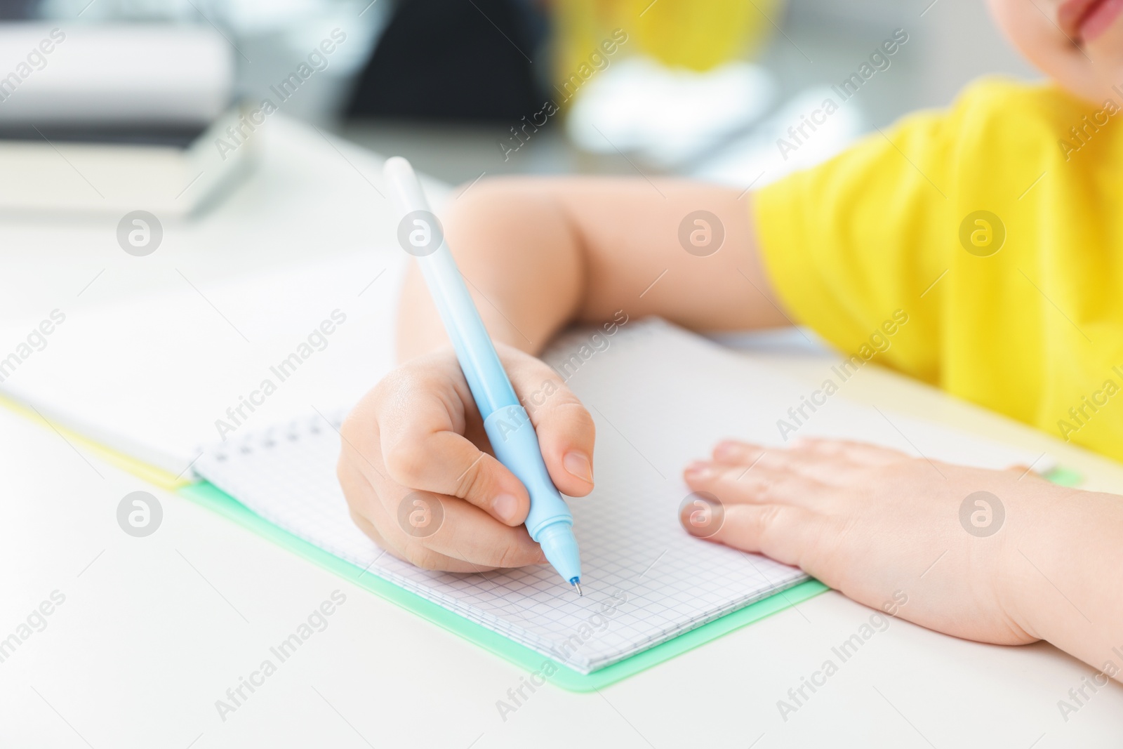 Little girl doing homework at table indoors, closeup Photo of Little girl doing homework at table indoors, closeup